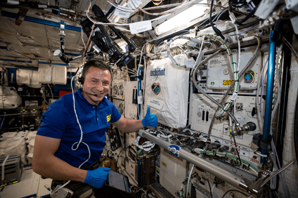 astronaut andrew morgan setting up equipment inside the space station