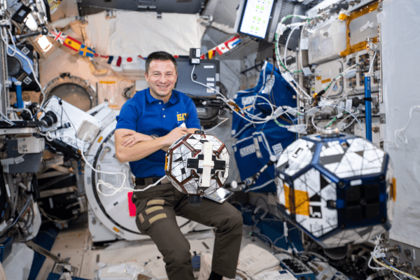 astronaut andrew morgan with the SPHERES satellites inside the space station