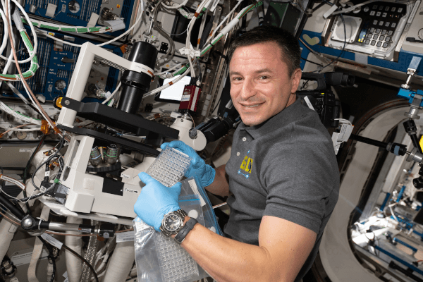 astronaut andrew morgan running science experiments inside the space station